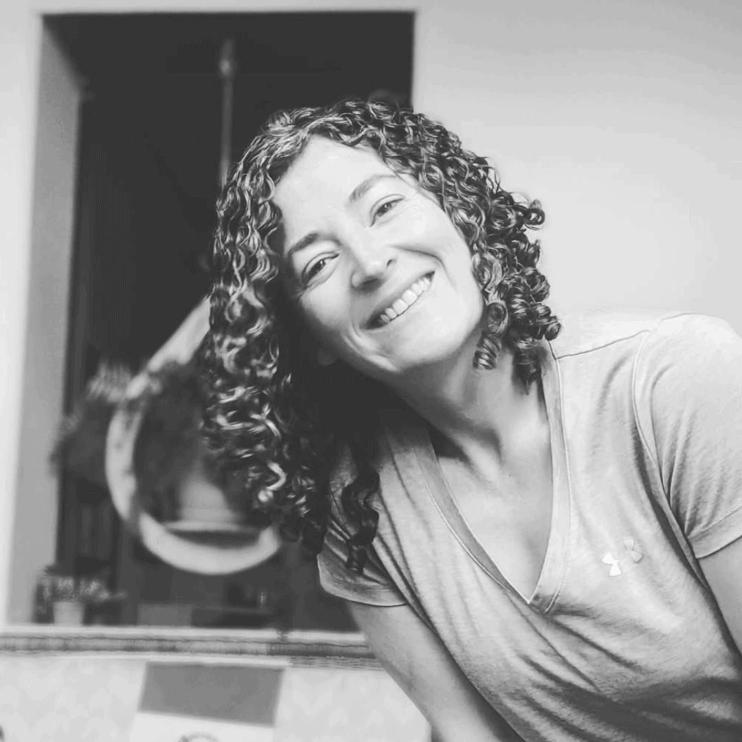 A grayscale image of a curly-haired woman in her 30s