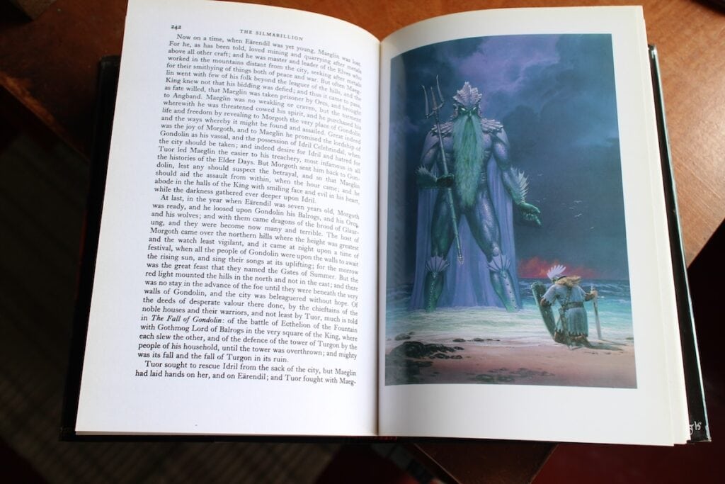 A human figure in armor kneels at the edge of the sea while a towering god-like man with fish scales stands before him. Tolkien's worlds include many ancient races, a common fantasy book trope