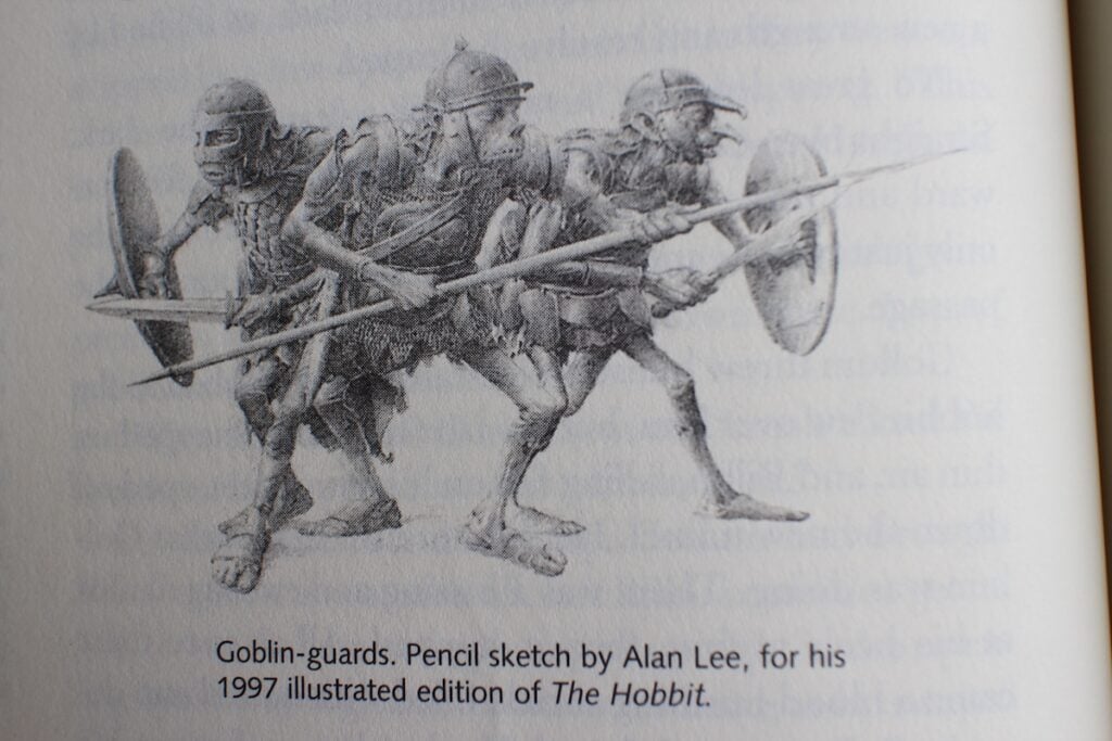 Three goblins in armor stand ready to repel attack with their shields and spears.
