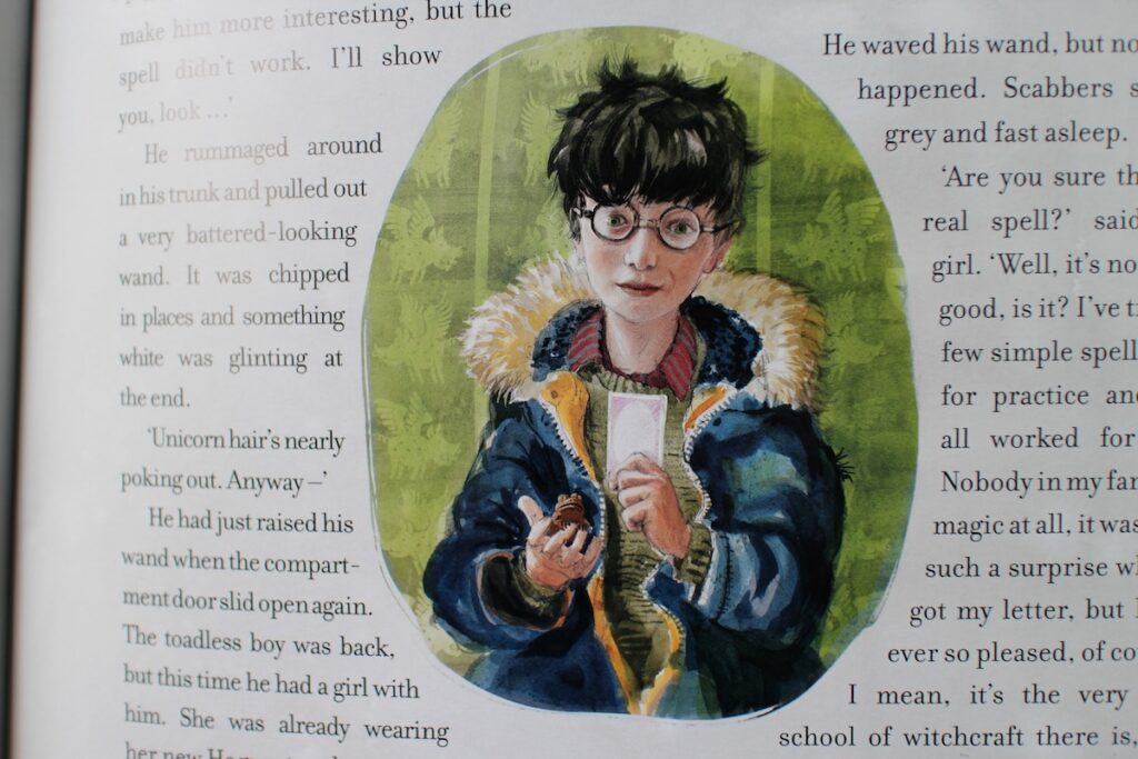 An illustration of Harry Potter with his glasses and messy black hair, reading a chocolate frog card on the crimson express to Hogwarts School of Witchcraft and Wizardry.
