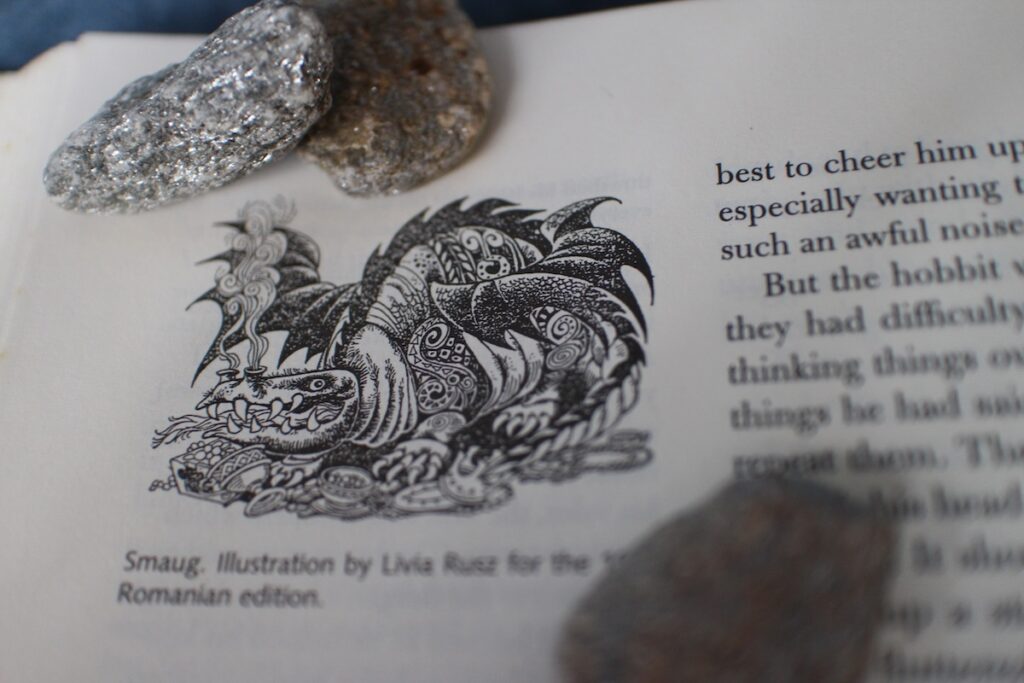 A pen drawing of Smaug, the dragon from J.R.R. Tolkien's "The Hobbit", crouches over his hoard of treasure with a fierce expression. This is a great example of the adventure fantasy subgenre.