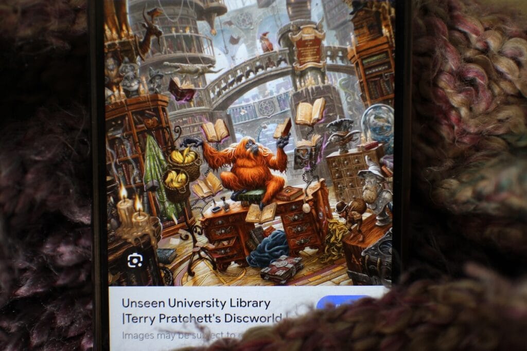 An orangutan sits in a library surrounded by books and bananas.