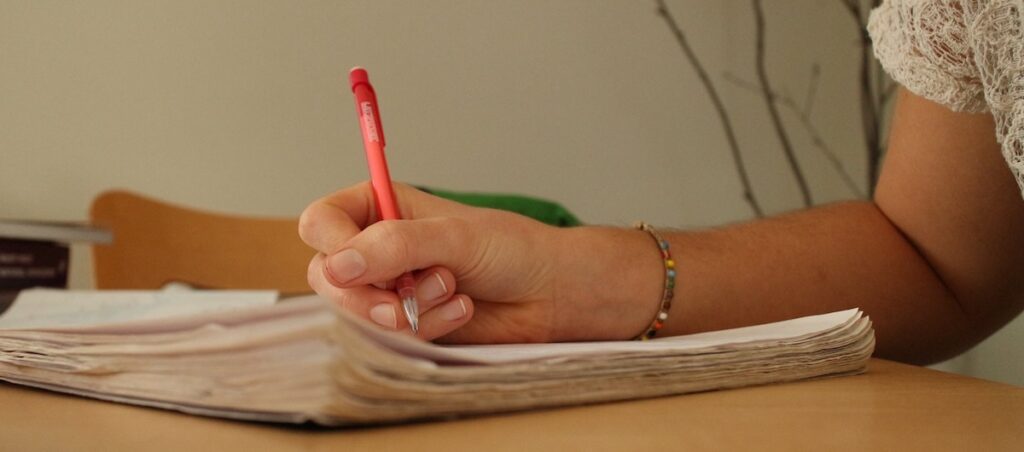 A woman writes in a notebook.