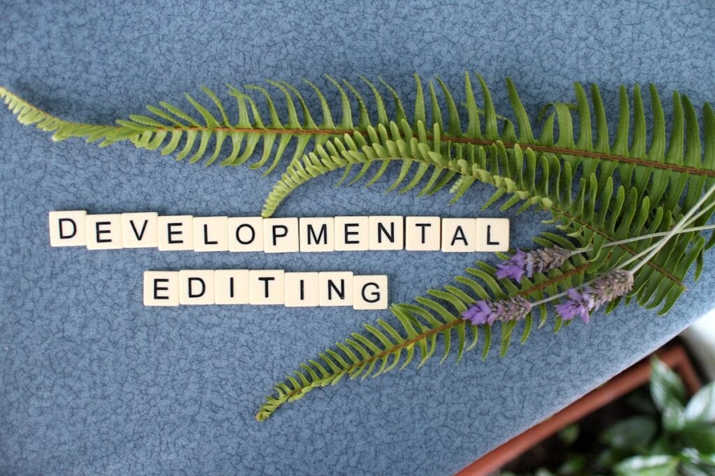 Bananagram tiles spell out "Developmental Editing" and are surrounded by fern and lavender sprigs